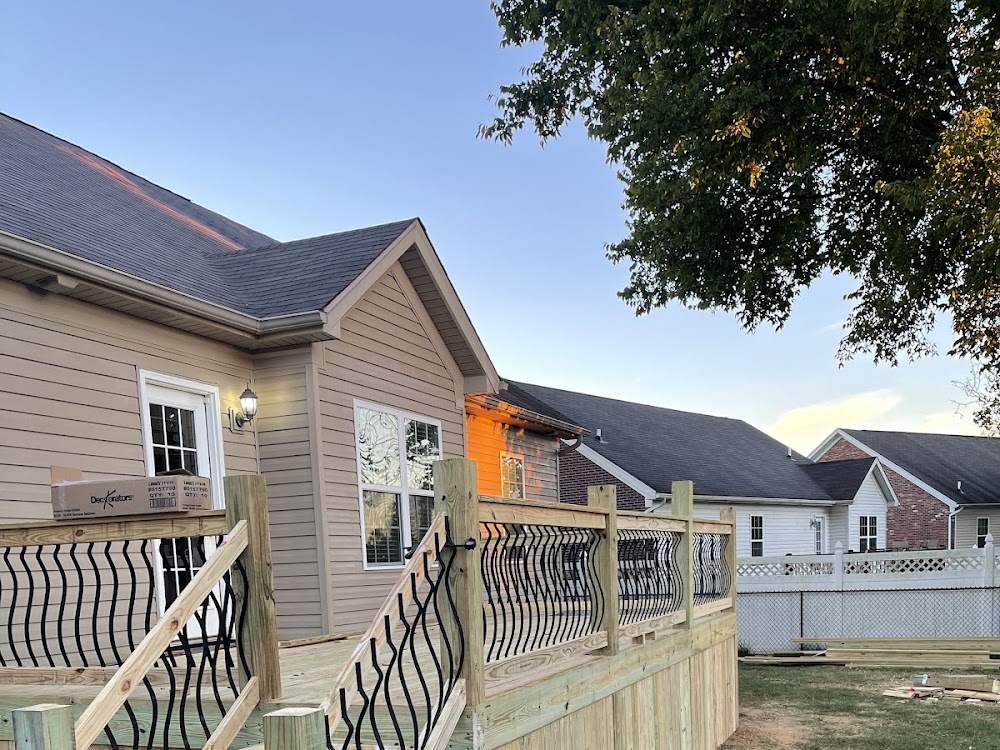 A finished wooden deck with a custom scroll-pattern railing.