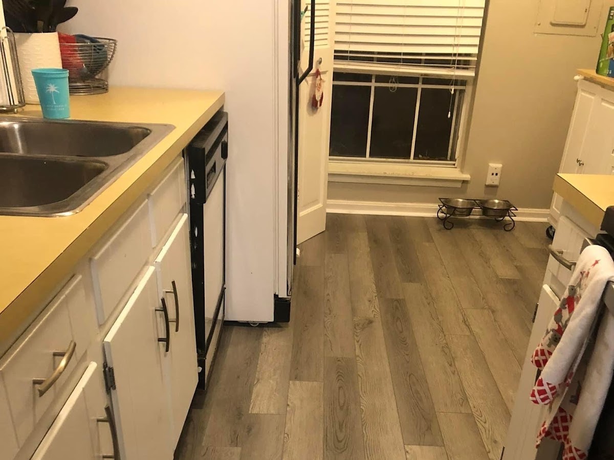A newly laid kitchen floor, boards running the length of the room.